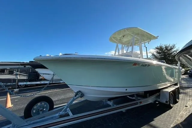 Slide: The Image of 2022 Sea Hunt Ultra 234 boat on trailer, parked beside an RV under clear blue sky. - 20