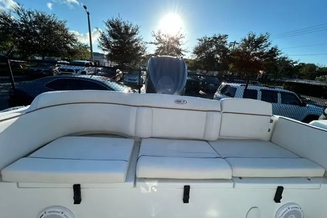 Slide: The Image of 2022 Sea Hunt Ultra 234 boat, side view, showcasing deck and seating under clear blue sky. - 4