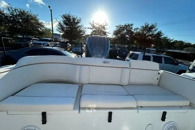 Slide: The Image of 2022 Sea Hunt Ultra 234 boat with cushioned seating, parked under a bright sun. - 5