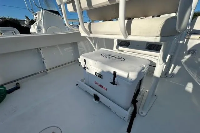 Slide: The Image of 2022 Sea Hunt Ultra 234 boat with cushioned seating, parked under a bright sun. - 6