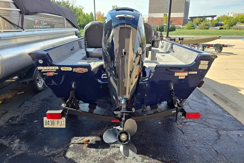 Slide: The Image of 2023 Tracker Pro Guide V-16 SC boat with outboard motor, parked on a trailer. - 2