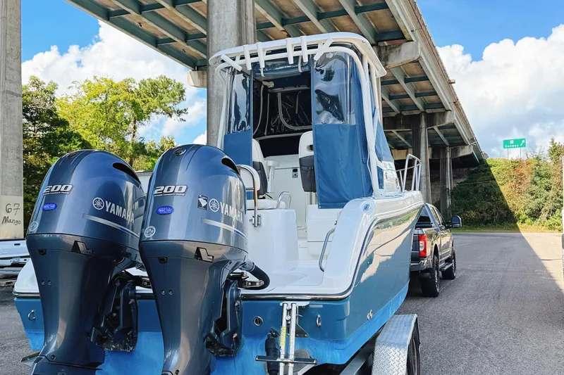 Slide: The Image of 2016 Century 2600 Walkaround boat with dual Yamaha 200 engines under a bridge. - 2