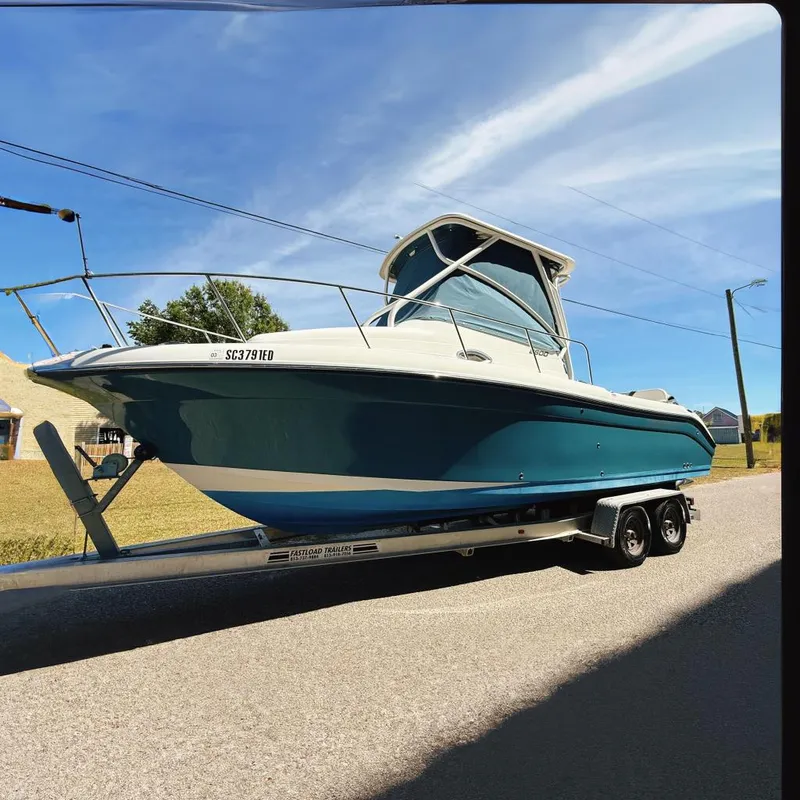Slide: The Image of 2016 Century 2600 Walkaround boat on trailer, parked on a sunny street. - 3