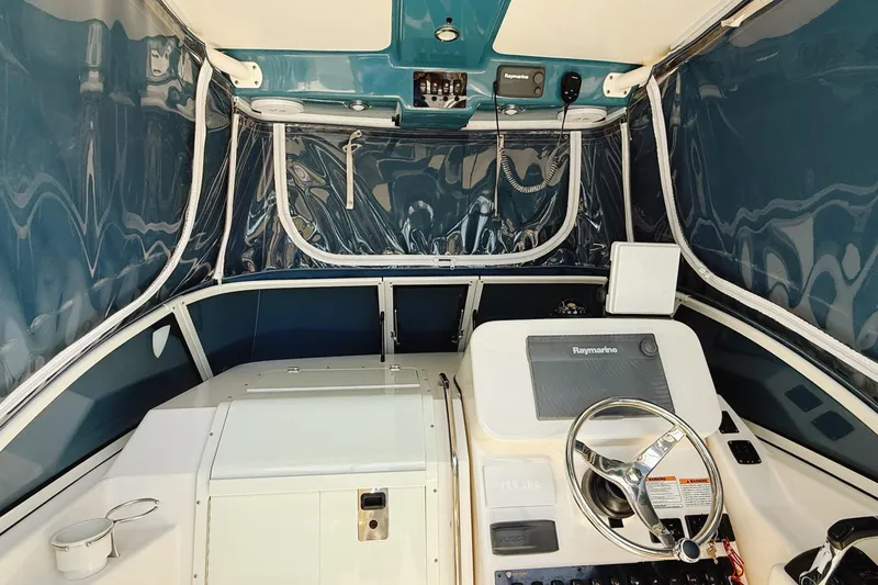 Slide: The Image of 2016 Century 2600 Walkaround boat interior with steering wheel and navigation equipment. - 6
