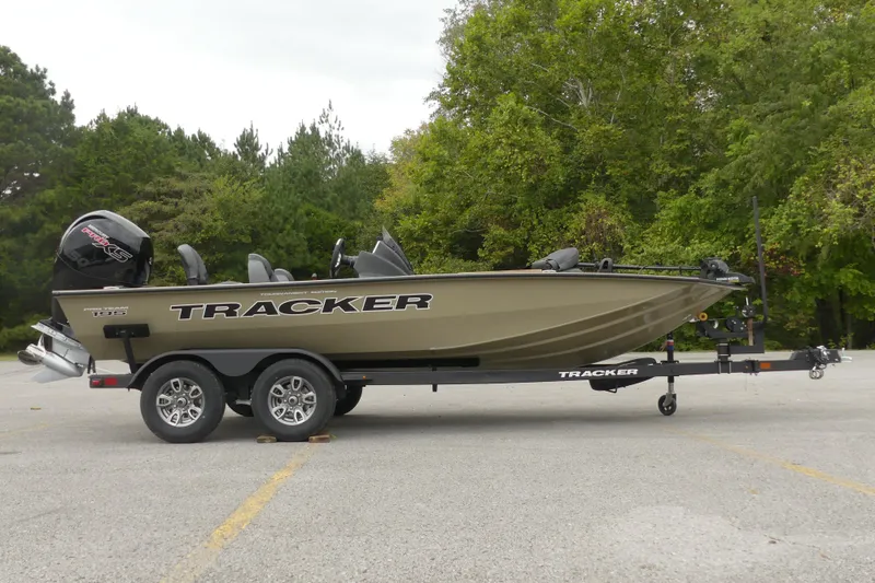 The Image of 2026 Tracker Pro Team 195 boat on trailer, parked in a wooded area. - 0