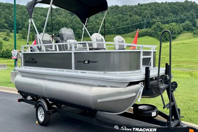 Slide: The Image of 2026 Sun Tracker Bass Buggy 16 XL Select pontoon boat interior with seating and steering console. - 2
