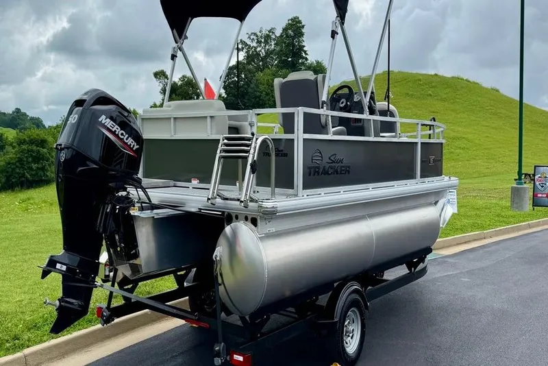 Slide: The Image of 2026 Sun Tracker Bass Buggy 16 XL Select pontoon boat with Mercury engine on trailer. - 3