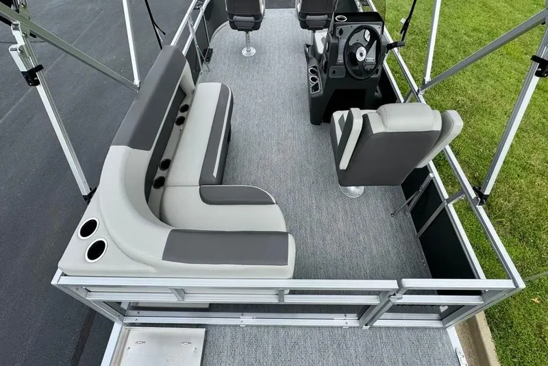 Slide: The Image of 2026 Sun Tracker Bass Buggy 16 XL Select pontoon boat on trailer, scenic background. - 5