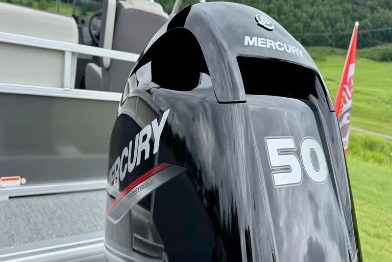 Slide: The Image of 2026 Sun Tracker Bass Buggy 16 XL Select pontoon boat on trailer, scenic background. - 7