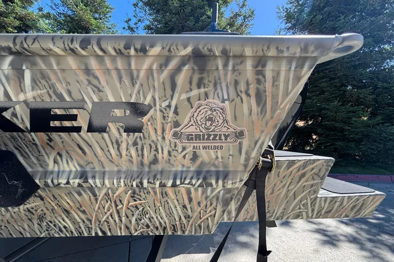 Slide: The Image of 2026 Tracker Grizzly 1654 T Sportsman boat with camouflage design and "All Welded" logo. - 13