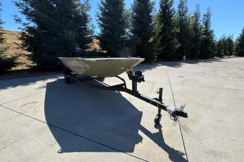 Slide: The Image of 2026 Tracker Grizzly 1654 T Sportsman boat on trailer in sunny outdoor setting. - 2