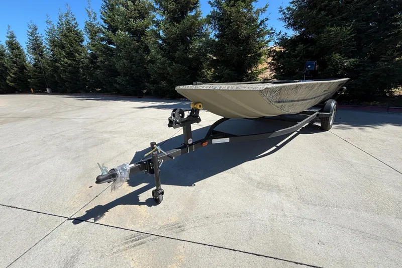 Slide: The Image of 2026 Tracker Grizzly 1654 T Sportsman boat on trailer, parked outdoors. - 4