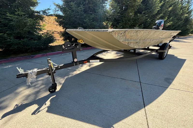 Slide: The Image of 2026 Tracker Grizzly 1654 T Sportsman boat on trailer, parked outdoors. - 8