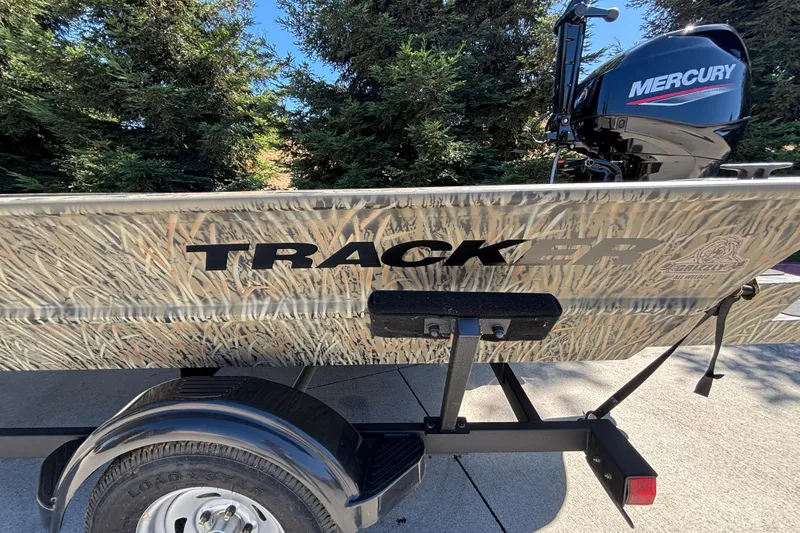 Slide: The Image of 2026 Tracker Grizzly 1654 T Sportsman boat with camouflage design and Mercury outboard motor. - 14