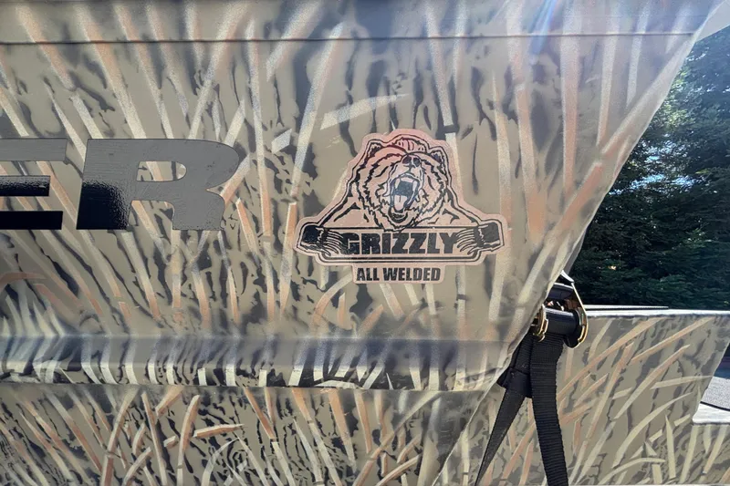 Slide: The Image of 2026 Tracker Grizzly 1654 T Sportsman boat with camo design and "All Welded" logo. - 22