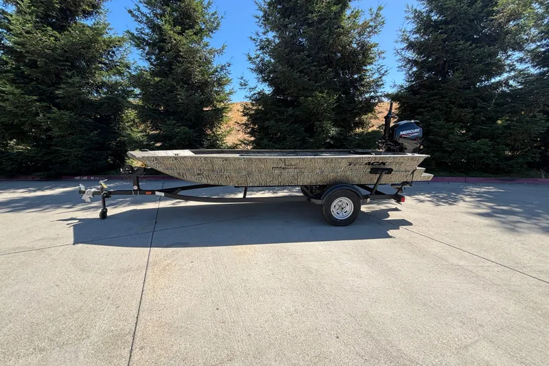 The Image of 2026 Tracker Grizzly 1654 T Sportsman boat on trailer, parked outdoors. - 0