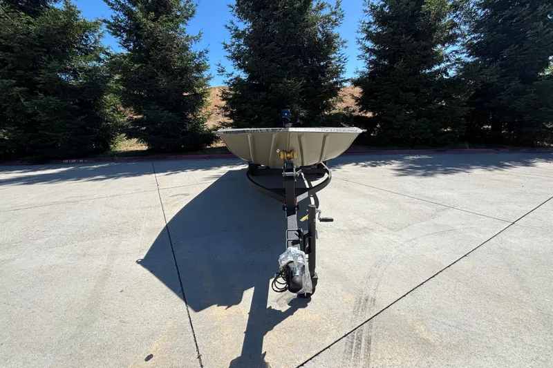 Slide: The Image of 2026 Tracker Grizzly 1654 T Sportsman boat on trailer, parked outdoors. - 3