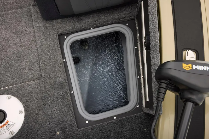 Slide: The Image of Open storage compartment in 2026 Tracker Targa V-18 Combo boat, featuring red and gray design. - 20
