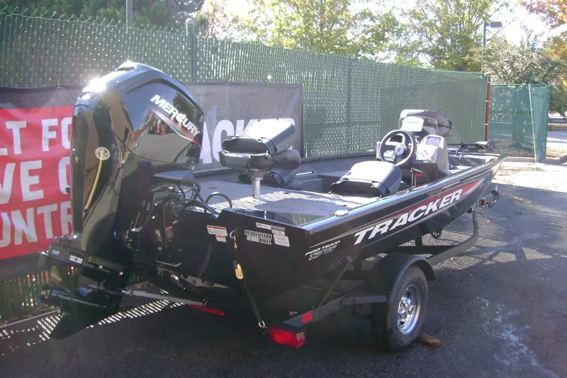 Slide: The Image of 2026 Tracker Pro Team 175 Crappie Edition boat with Mercury engine, parked outdoors. - 2
