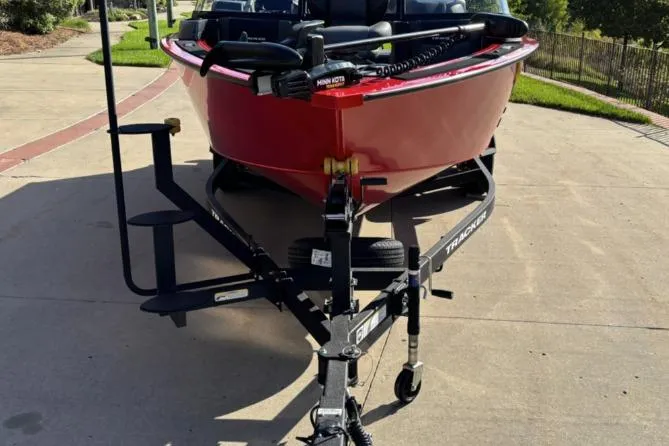 Slide: The Image of 2026 Tracker Targa V-19 Combo boat on trailer, parked on a sunny driveway. - 11