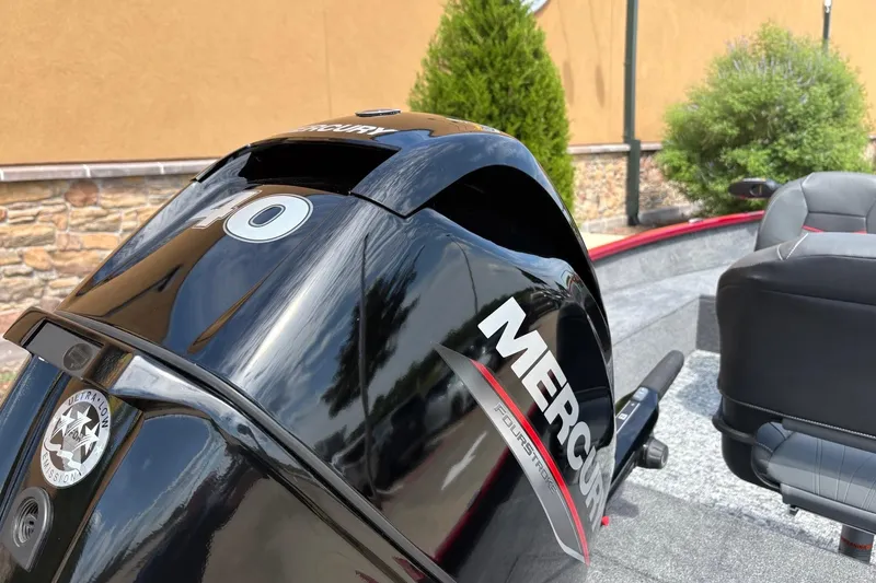 Slide: The Image of 2026 Tracker Super Guide V-16 T with Mercury outboard motor, parked outdoors. - 32