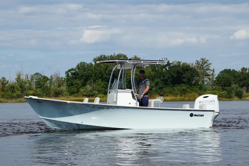 The Image of 2023 Maycraft 2100 CC boat on water with Suzuki engine, surrounded by trees. - 1