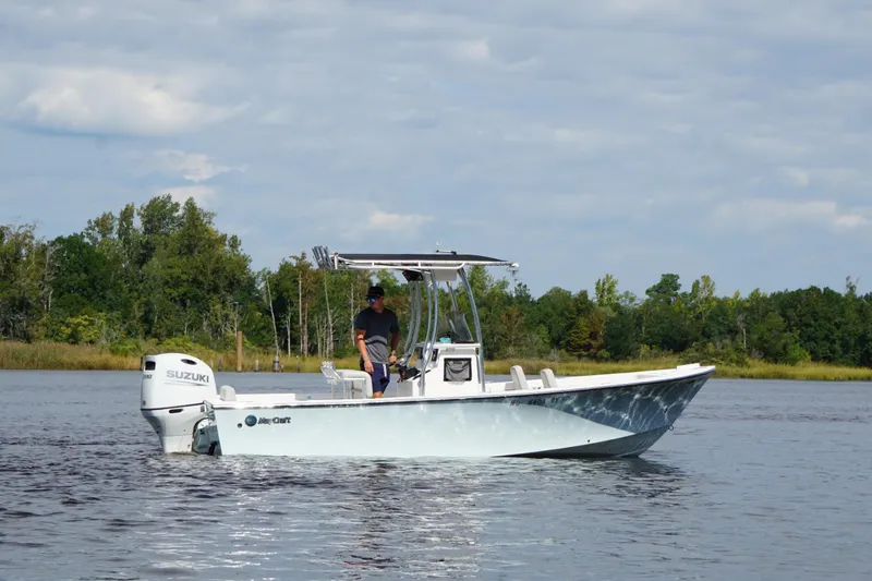 Slide: The Image of 2023 Maycraft 2100 CC boat on calm water with Suzuki engine, surrounded by trees. - 3