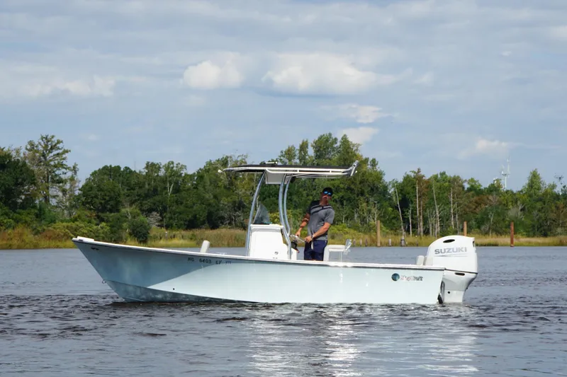 Slide: The Image of 2023 Maycraft 2100 CC boat on a calm lake with a Suzuki engine. - 4