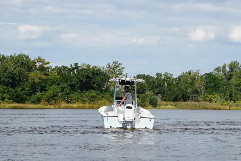 Slide: The Image of 2023 Maycraft 2100 CC boat cruising on a scenic river with lush greenery. - 7