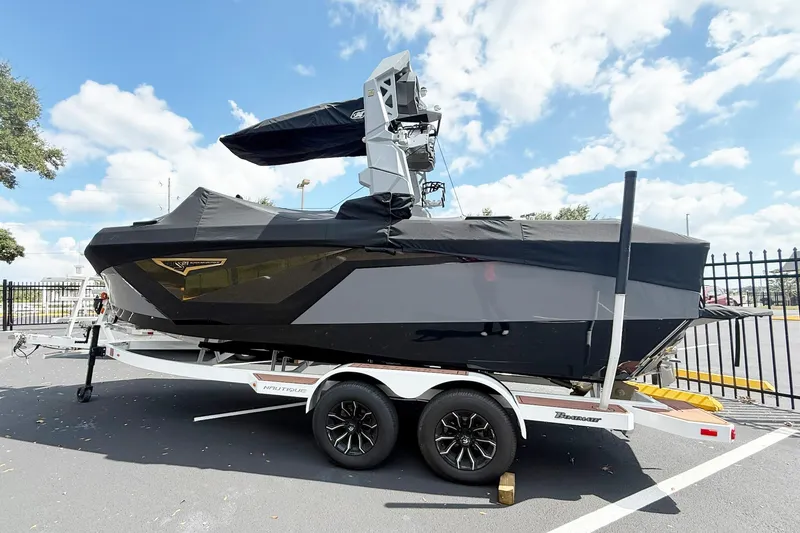 The Image of 2025 Nautique Super Air Nautique S21 boat on trailer, covered, outdoors. - 1