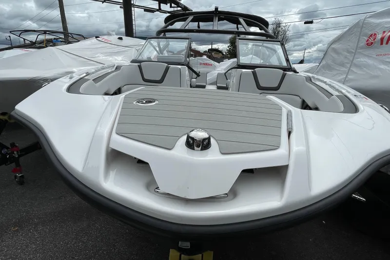 Slide: The Image of 2026 Yamaha AR250 boat with sleek design, parked outdoors under cloudy skies. - 2