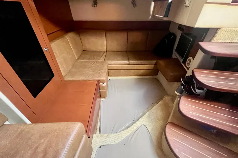 Slide: The Image of Interior of 2007 Sea Ray 38 Sundancer with tan leather seating and wooden steps. - 12
