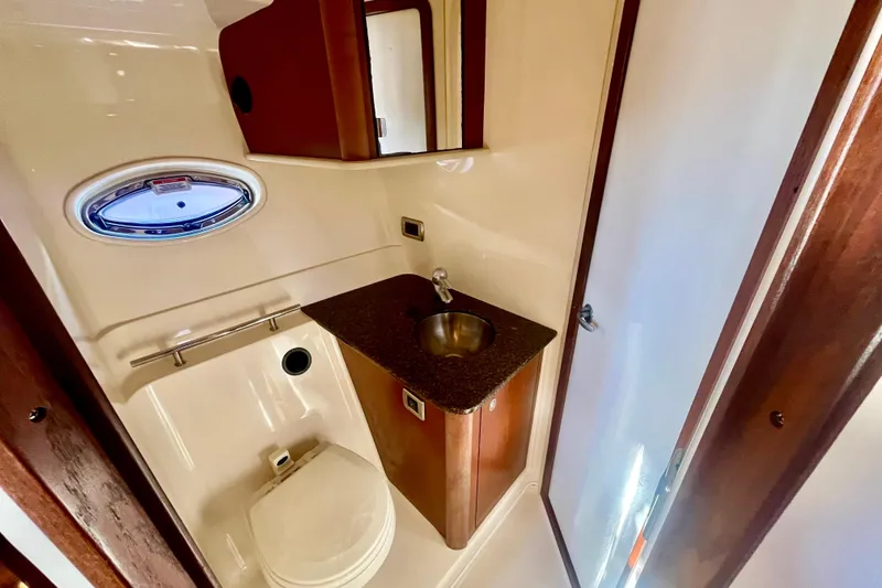 Slide: The Image of 2007 Sea Ray 38 Sundancer bathroom with sink, toilet, and porthole window. - 15
