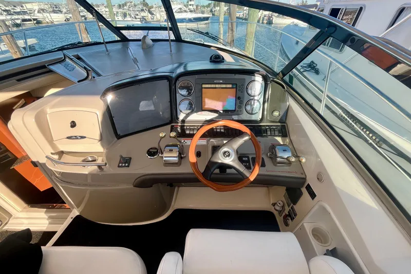 Slide: The Image of 2007 Sea Ray 38 Sundancer helm with navigation controls and wooden steering wheel. - 7