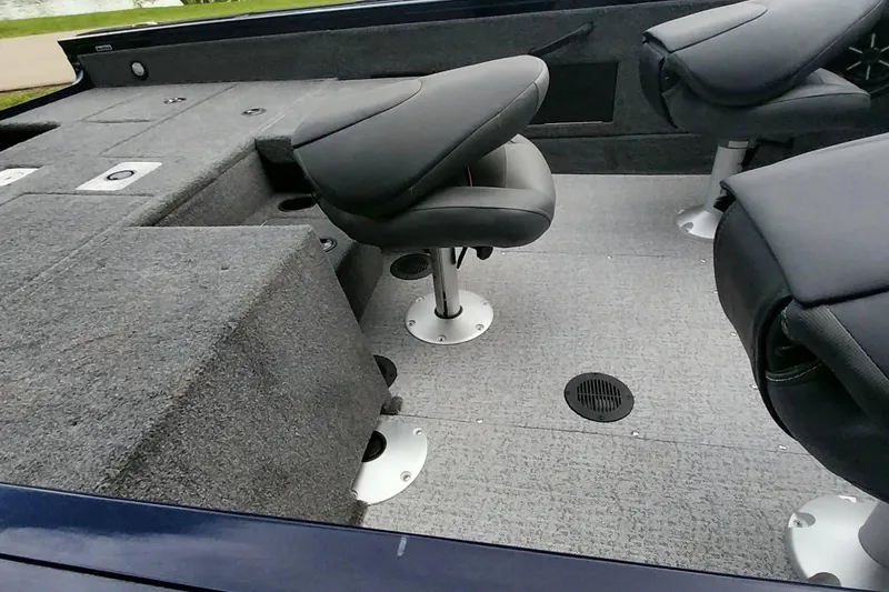 Slide: The Image of 2024 Tracker Targa V-18 Combo boat interior with swivel seats and carpeted flooring. - 15