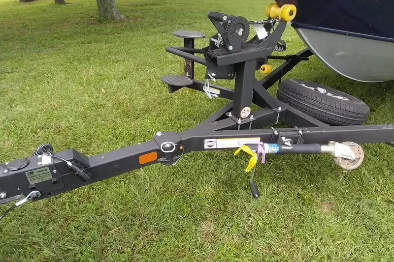 Slide: The Image of 2024 Tracker Targa V-18 Combo trailer hitch on grassy field. - 26