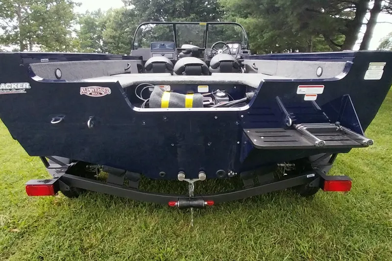 Slide: The Image of 2024 Tracker Targa V-18 Combo boat rear view on grass, showcasing hull and trailer. - 3