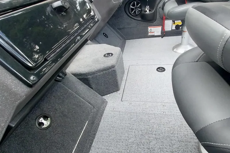 Slide: The Image of 2024 Tracker Targa V-18 Combo interior with gray carpet and black seating. - 39