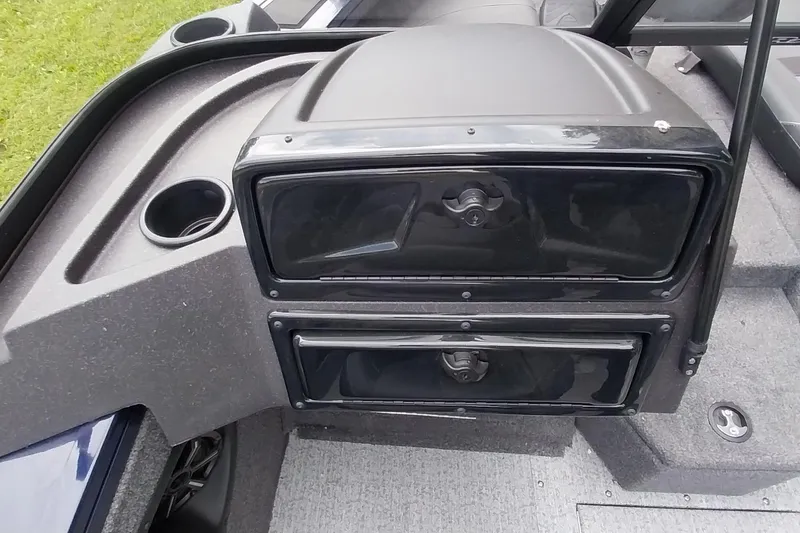 Slide: The Image of 2024 Tracker Targa V-18 Combo boat dashboard with storage compartments and cup holder. - 47