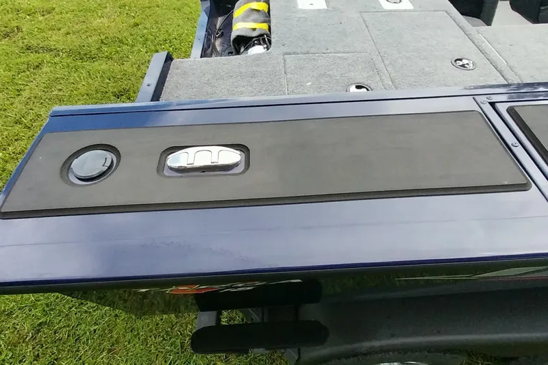 Slide: The Image of 2024 Tracker Targa V-18 Combo boat deck with storage compartments on grassy background. - 8