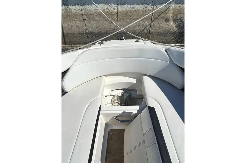 Slide: The Image of 2022 Sea Ray SPX 230 Outboard boat interior with white seating and storage compartment. - 17