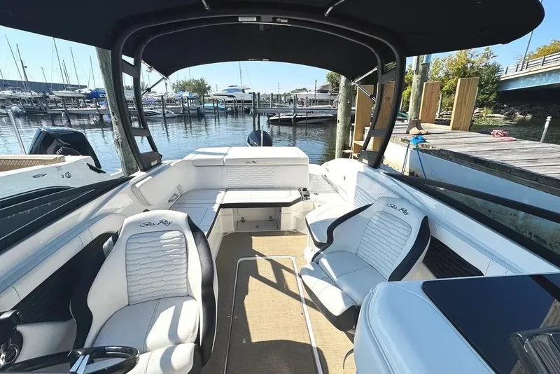 Slide: The Image of 2022 Sea Ray SPX 230 Outboard boat interior at marina, featuring comfortable seating and sleek design. - 24