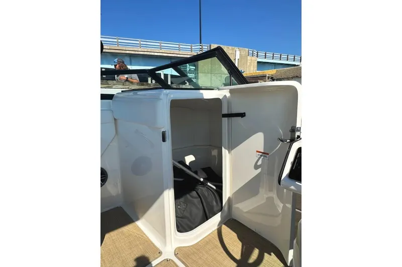 Slide: The Image of 2022 Sea Ray SPX 230 Outboard boat interior storage compartment with open door. - 33