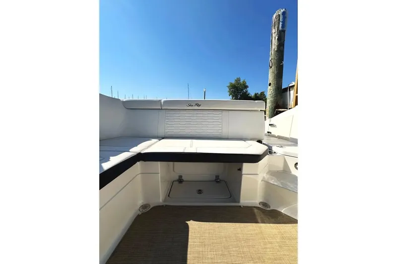 Slide: The Image of 2022 Sea Ray SPX 230 Outboard boat interior with white seating and sunny sky. - 34