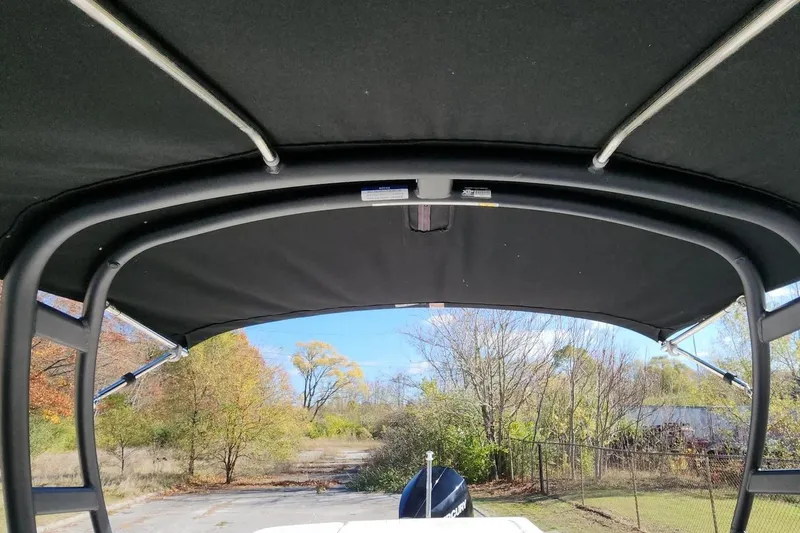 Slide: The Image of 2022 Sea Ray SPX 230 Outboard boat with black canopy, scenic background. - 39