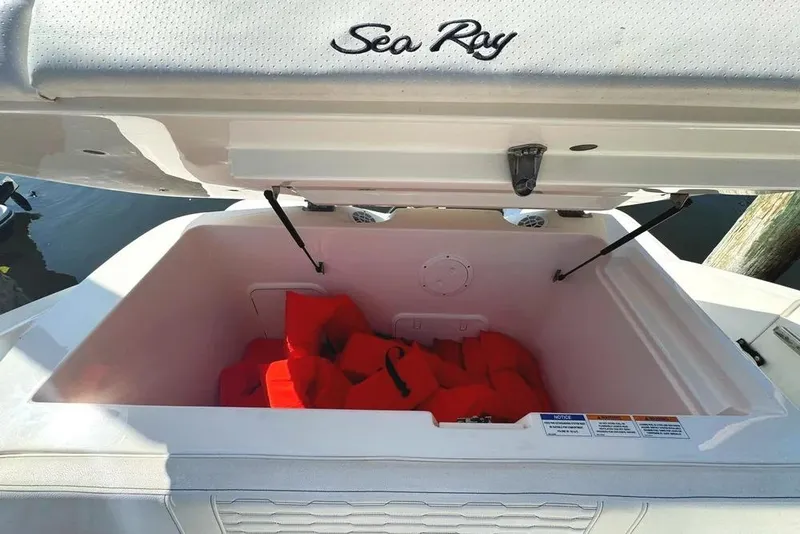 Slide: The Image of Open storage compartment on 2022 Sea Ray SPX 230 Outboard with life jackets inside. - 45