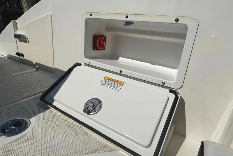 Slide: The Image of 2022 Sea Ray SPX 230 Outboard storage compartment with safety warning label. - 49
