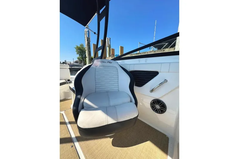 Slide: The Image of 2022 Sea Ray SPX 230 Outboard boat seat with speaker and handle, docked under clear sky. - 8