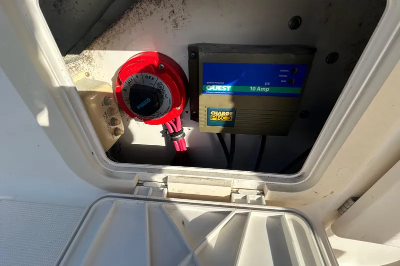 Slide: The Image of Battery switch and charger in 2000 Pursuit 2470 Walkaround boat compartment. - 12