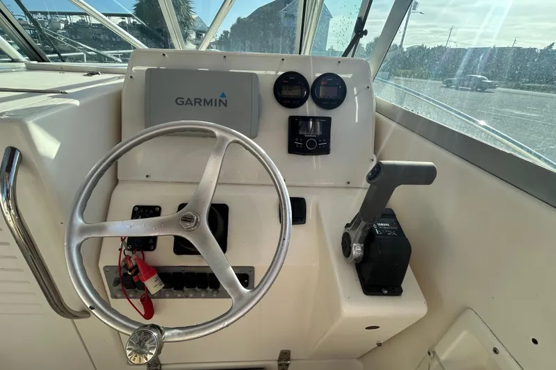 Slide: The Image of 2000 Pursuit 2470 Walkaround boat helm with Garmin navigation and Yamaha controls. - 13